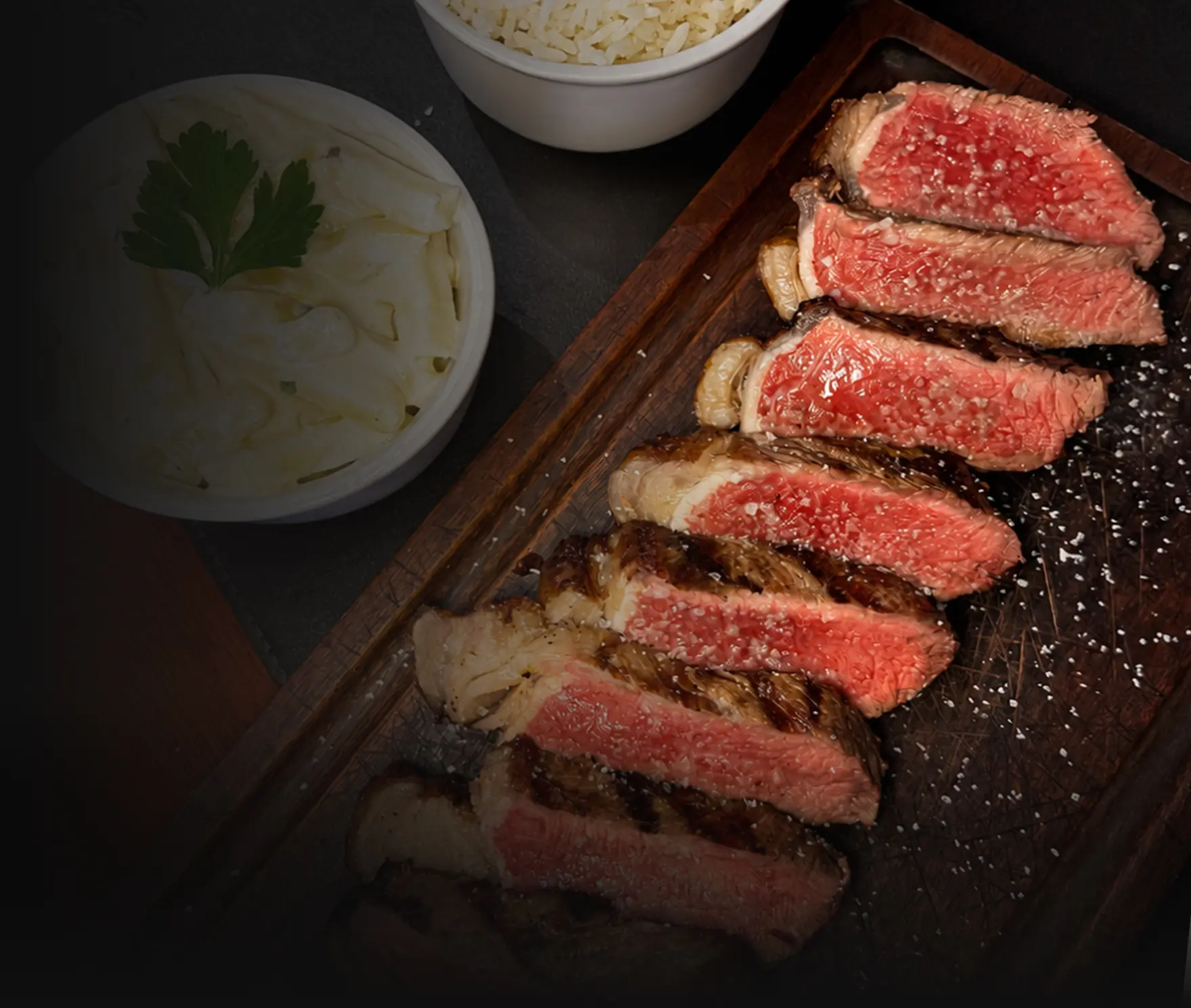 Tábua com carne fatiada suculenta, especialidade da Steak Ranch Paranavaí, boutique de carnes e churrasco